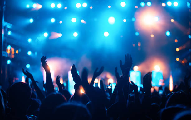 La imagen muestra unas manos en el aire con una ambientación de colores neón, dando la sensación que esas personas están en un festival o una discoteca.