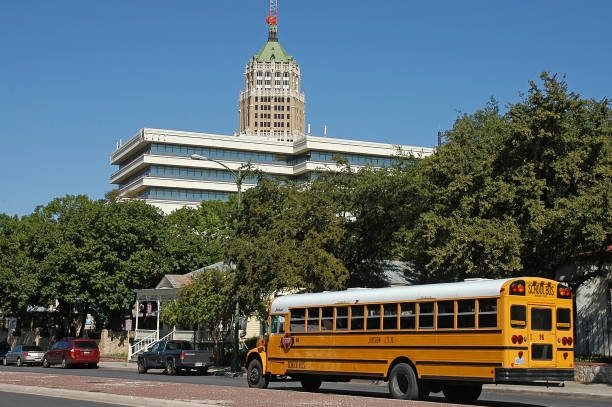 En la imagen se ve un típico bus escolar americano en carretera por la ciudad.