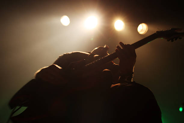 En la imagen se ve como protagonista a una persona tocando la guitarra en un escenario.